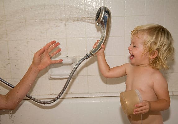 Un enfant joue dans une douche