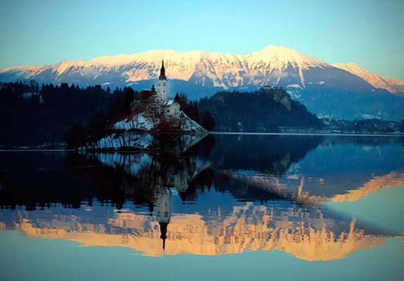 Le reflet sur l'eau d'une montagne et d'un clocher